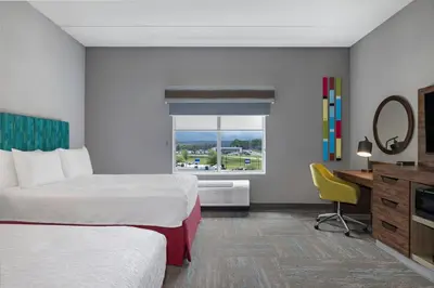 a hotel room with two beds and a desk and a window at Hampton Inn Midland, On in Midland