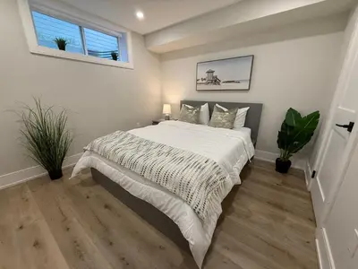 a bedroom with a large bed with white sheets and pillows at Modern 1BR - Heart of Queen West in Toronto