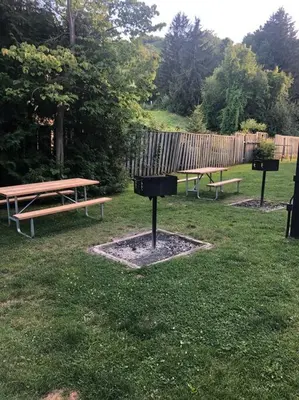 two picnic tables and a grill in a park at Freshly Upgraded Cozy Loft @ North Creek Resort in Blue Mountains