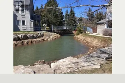 a river with a bridge in a residential neighborhood at Freshly Upgraded Cozy Loft @ North Creek Resort in Blue Mountains