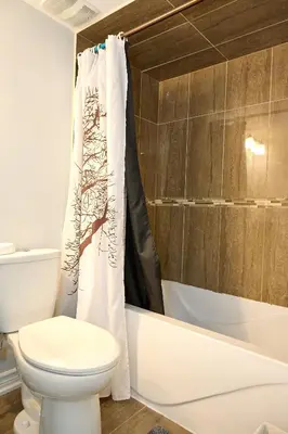 a bathroom with a toilet and a shower curtain at Peace Alcove in Milton