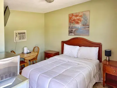a bedroom with a bed and a desk with a computer at Sunny Motel Port Elgin in Port Elgin