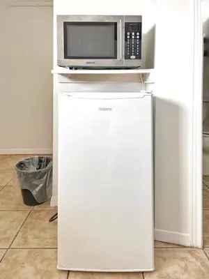 a microwave sitting on top of a refrigerator at Sunny Motel Port Elgin in Port Elgin