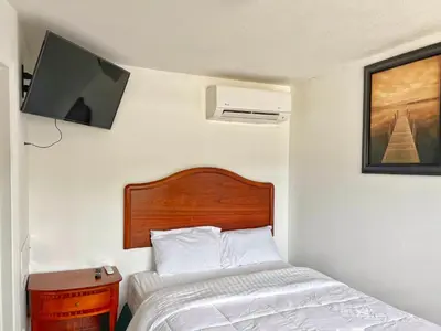 a bedroom with a bed and a tv on the wall at Sunny Motel Port Elgin in Port Elgin
