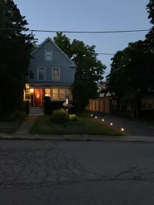 a house with lights on the front yard at night at Ambiance by the Falls Cozy Suite in Niagara Falls