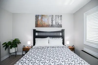 a bedroom with a bed and a painting on the wall at Slopeside Sanctuary - Ski In/Ski Out in Blue Mountains
