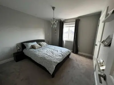 a bedroom with a bed and a chandelier at Cozy 3 bedroom home perfect for small gatherings in Barrie