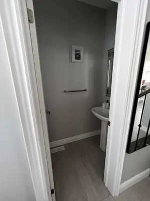 a white bathroom with a sink and a mirror at Cozy 3 bedroom home perfect for small gatherings in Barrie
