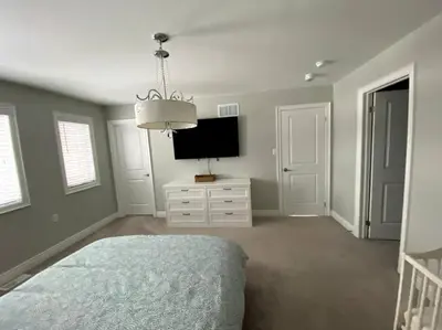 a bedroom with a bed and a flat screen tv at Cozy 3 bedroom home perfect for small gatherings in Barrie
