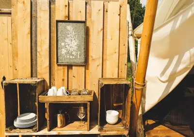 a wooden wall with two wooden tables and a picture at Fronterra Wellness Farm & Camp in Hillier