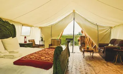 a bedroom with a bed and a tent at Fronterra Wellness Farm & Camp in Hillier