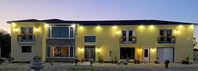 a large yellow house with lights on it at Villa di Casa - Boutique Hotel in Wellington
