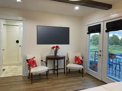 a room with a table and two chairs and a television at Villa di Casa - Boutique Hotel in Wellington