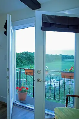 a door to a balcony with a view of the water at Villa di Casa - Boutique Hotel in Wellington
