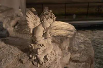 a statue of an angel sitting on a rock at Villa di Casa - Boutique Hotel in Wellington
