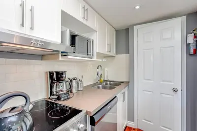 a small kitchen with white cabinets and a sink at Blue Mountain Luxury Studio in Blue Mountains