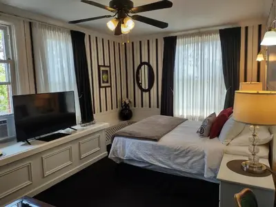 a bedroom with a bed and a flat screen tv at The King George Inn in Cobourg