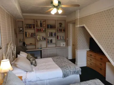 a bedroom with a bed and a book shelf at The King George Inn in Cobourg