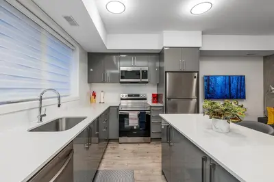a kitchen with white countertops and stainless steel appliances at Exquisite 2 Bedroom Apt, mins to the falls. in Niagara Falls