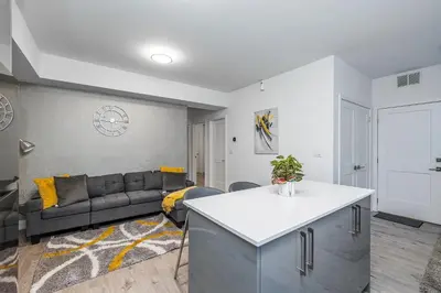 a living room with a couch and a table at Exquisite 2 Bedroom Apt, mins to the falls. in Niagara Falls