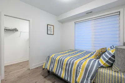 a bedroom with a bed and a window at Exquisite 2 Bedroom Apt, mins to the falls. in Niagara Falls