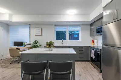 a kitchen with a large island with chairs in it at Exquisite 2 Bedroom Apt, mins to the falls. in Niagara Falls