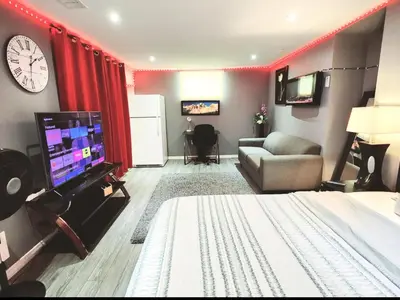 a room with a bed and a couch and a tv at Staycation Studio Apartment, Private kitchen , Washroom, Micro Gym & Free Onsite Parking in London