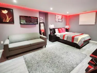 a bedroom with a bed and a couch and a tv at Staycation Studio Apartment, Private kitchen , Washroom, Micro Gym & Free Onsite Parking in London