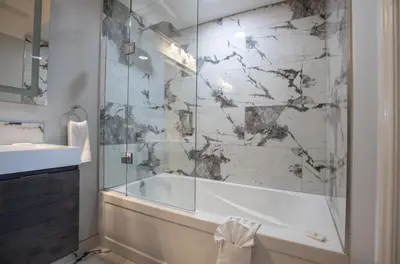 a bathroom with a tub and a glass shower at Niagara Luxury Suites in Niagara Falls