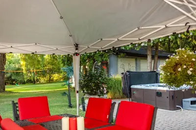 a group of red chairs under a white umbrella at Nature Oasis Mar Suite in Dundas