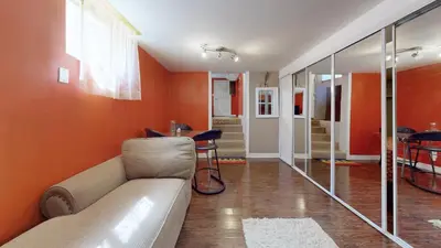 a living room with orange walls and a couch at ZARA's UNIQUE APARTMENT in Mississauga