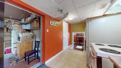 a kitchen with an orange wall and a stove at ZARA's UNIQUE APARTMENT in Mississauga