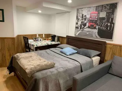 a bedroom with a bed and a couch and a red bus at BIG Oasis Studio near Airport YYZ in Toronto