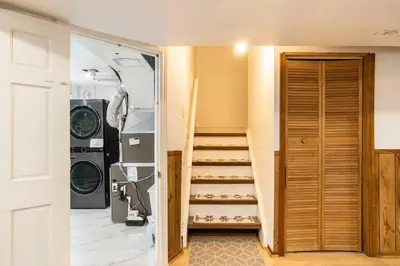 a laundry room with a staircase and a washer and dryer at BIG Oasis Studio near Airport YYZ in Toronto