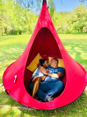 a man and a woman laying in a red tent at Nature Oasis Bar Room in Dundas