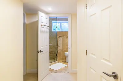 a bathroom with a toilet and a glass shower door at Nature Oasis Bar Room in Dundas