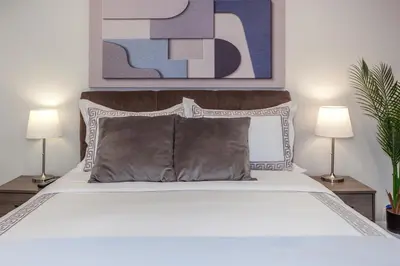 a bedroom with a white bed with two lamps at Nature Oasis Bar Room in Dundas