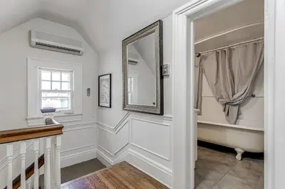 a bathroom with a mirror and a bath tub at Four Bedroom Rosedale Home in Toronto