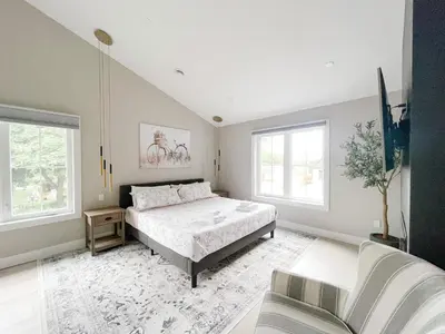 a bedroom with a bed and two windows at Inn On King Bed & Breakfast in Niagara on the Lake