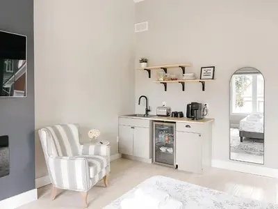 a living room with a chair and a kitchen at Inn On King Bed & Breakfast in Niagara on the Lake