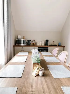 a dining room with a table and a kitchen at Inn On King Bed & Breakfast in Niagara on the Lake