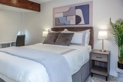 a bedroom with a large white bed and a plant at Nature Oasis BarMar 2BR Suite in Dundas close to Webster Falls in Dundas
