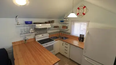 a kitchen with a white refrigerator and a wooden counter top at Plovers Cove Cottage in Wasaga Beach