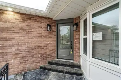 a brick house with a gray door and a window at Classic & Luxury Private Detached Entire Home with Free WI-FI & T.V in Brampton