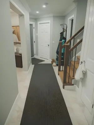 a hallway with a black rug on the floor at Classic & Luxury Private Detached Entire Home with Free WI-FI & T.V in Brampton