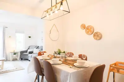 a white dining room with a table and chairs at Family-Friendly Boho Stay - Sleeps 10 - Near the Falls in Thorold
