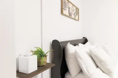 a room with a bed with white pillows at Family-Friendly Boho Stay - Sleeps 10 - Near the Falls in Thorold