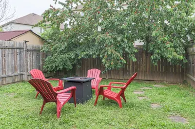 three red chairs and a trash can in a backyard at Family-Friendly Boho Stay - Sleeps 10 - Near the Falls in Thorold