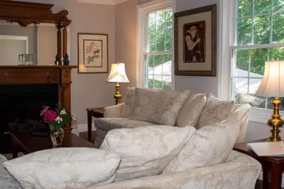 a living room with a white couch and a fireplace at Upper Canada Coach House in Niagara on the Lake