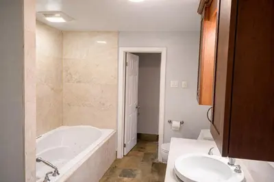 a bathroom with a tub and a toilet and a sink at Spacious 3 Plus 1 Bedroom 2 Bath Cottage Retreat with Fire Pit and Pool Table in Brighton